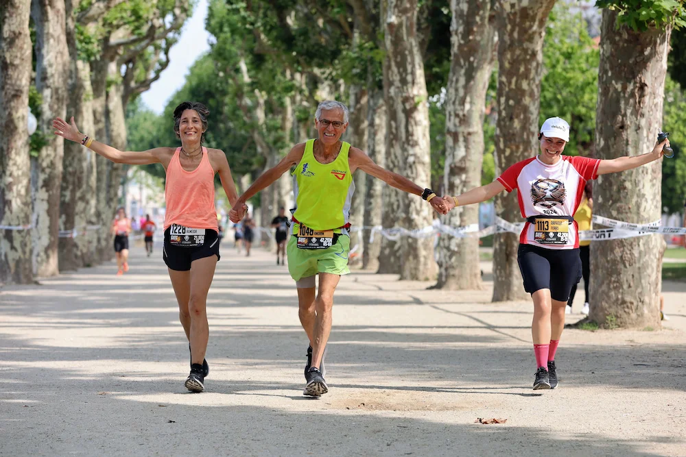 Three people running holding hands